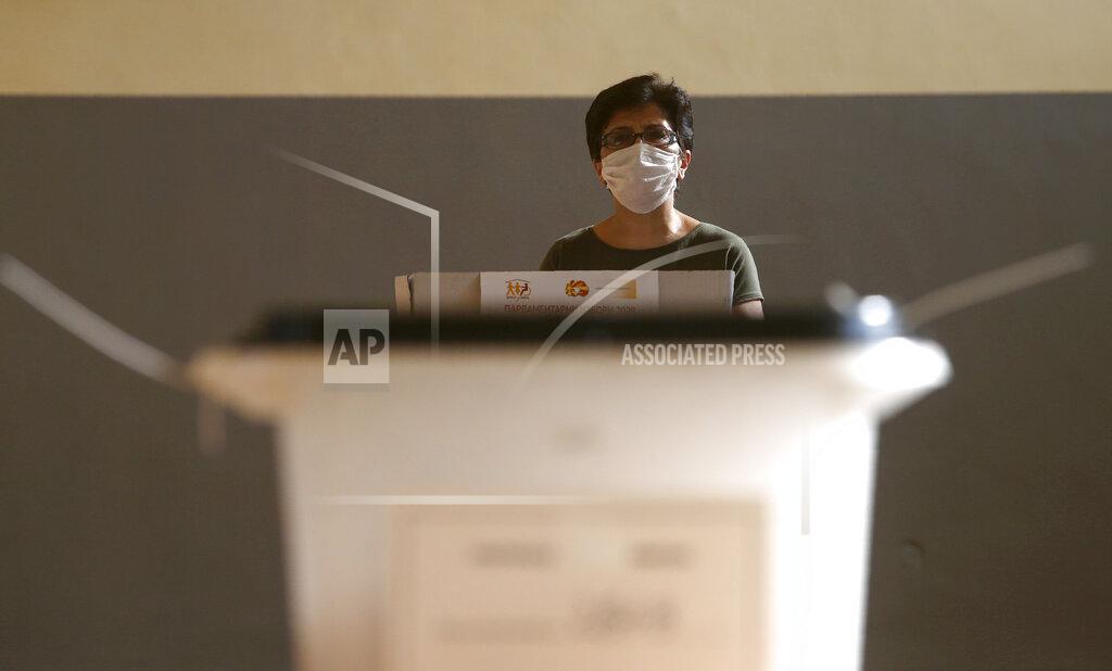 Boris Grdanoski A woman wearing a face mask to prevent the spread of coronavirus, looks on before casting her ballot for the parliamentary elections in a polling station in Skopje, North Macedonia on Wednesday, July 15, 2020. Voters in North Macedonia were heading to polls early on Wednesday in the country's general election despite an alarming spike in coronavirus cases in the tiny Balkan nation. (AP Photo/Boris Grdanoski)