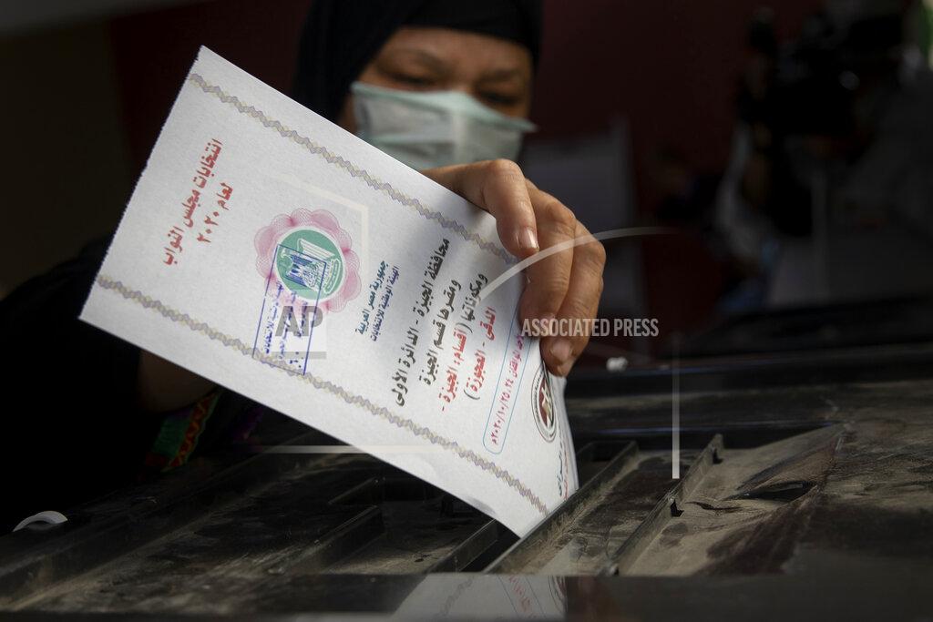 Nariman El-Mofty A woman casts her ballot on the first day of the parliamentary election inside a polling station in Giza, Egypt, Saturday, Oct. 24, 2020. Egyptians began voting Saturday in the first stage of a parliamentary election, a vote that is highly likely to produce a toothless House of Representatives packed with supporters of President Abdel-Fattah el-Sissi. (AP Photo/Nariman El-Mofty)