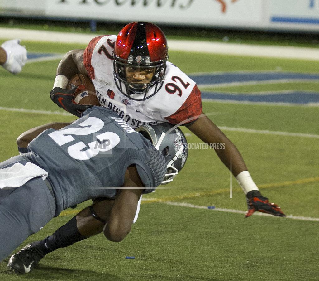 Tom R. Smedes San Diego State's Kobe Smith (92) is hit by Nevada's Jomon Dotson (23) in the second half of an NCAA college football game in Reno, Nev., Saturday, Oct. 27, 2018. (AP Photo/Tom R. Smedes)