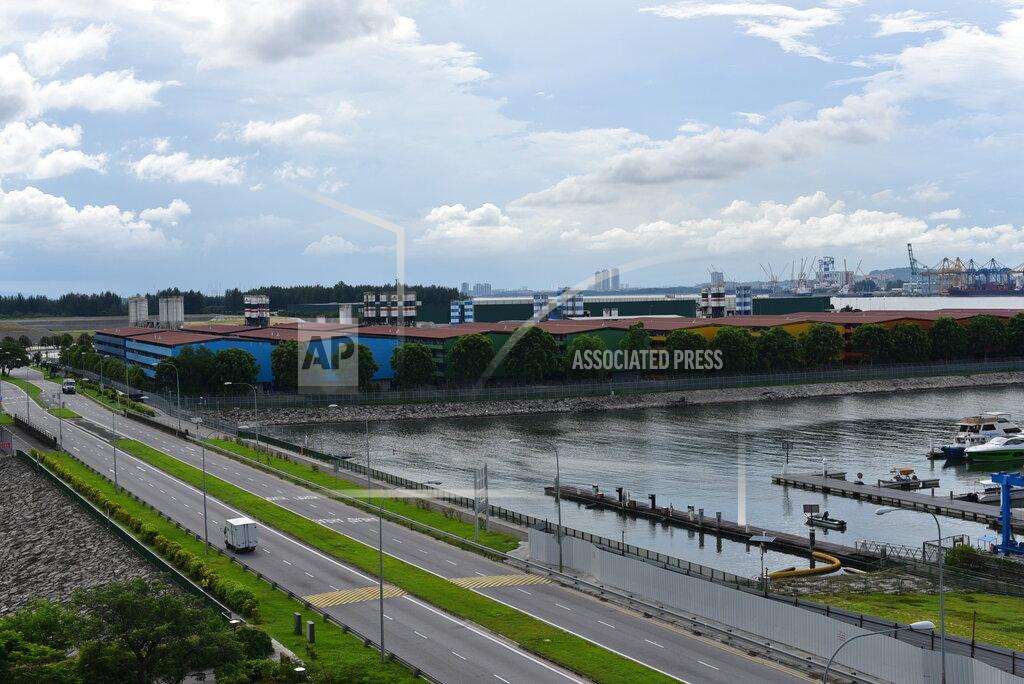 Yk Chan In this Sunday, May 10, 2020, photo, the S11@Punggol complex of dormitory buildings for foreign workers are seen behind a row of trees in Singapore. A second wave of coronavirus infections in tightly packed foreign workers' dormitories has caught Singapore off guard, and exposed the danger of overlooking marginal groups in a health crisis. (AP Photo/YK Chan)