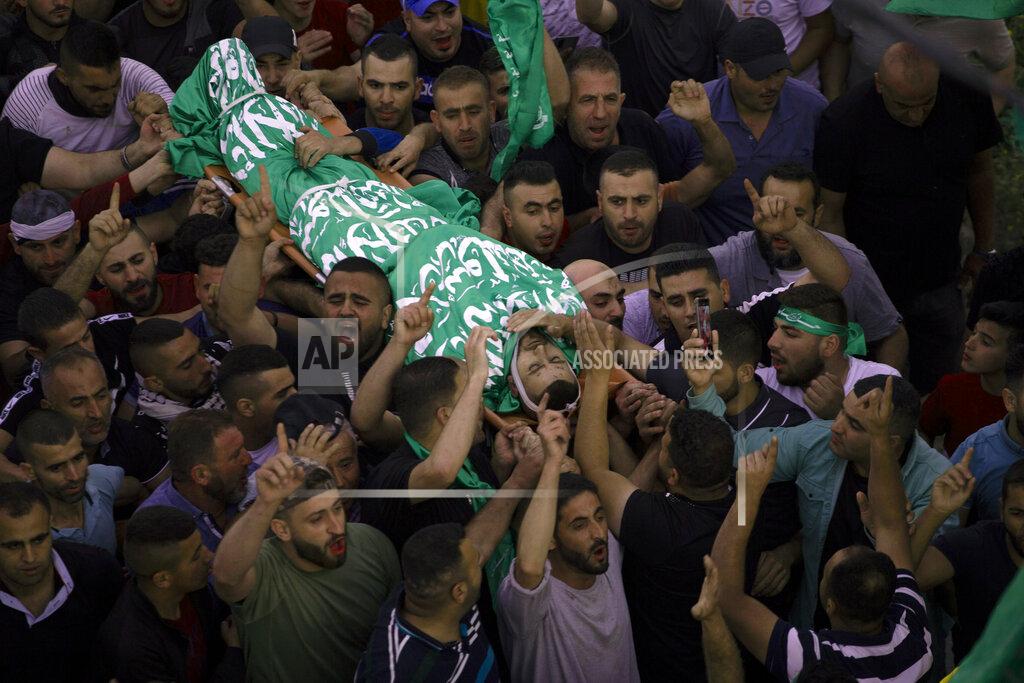 Majdi Mohammed Palestinian mourners carry the body of Nidal Safadi, who was killed in clashes with Israeli forces, during his funeral in the West Bank village of Urif, near Nablus, Friday, May 14, 2021.(AP Photo/Majdi Mohammed)