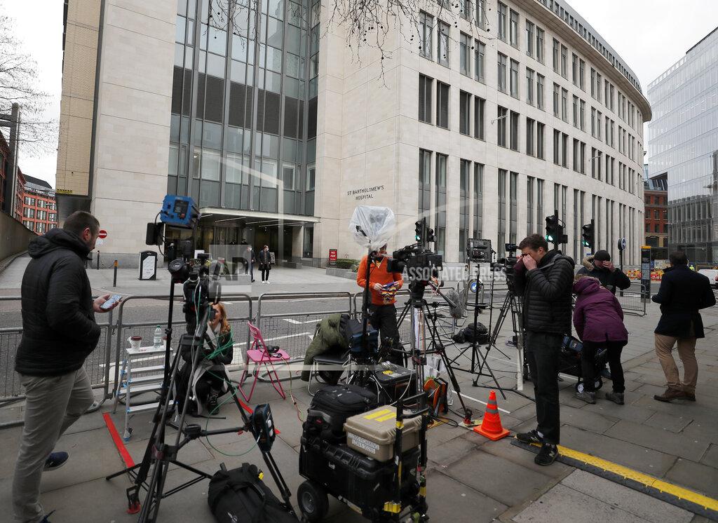 Frank Augstein Members of the media stand outside the main entrance of St Bartholomew's Hospital where Britain's Prince Philip is being treated in London, Friday, March 5, 2021. Buckingham Palace says Prince Philip has had a successful heart procedure in a London hospital. The palace says the 99-year-old Duke of Edinburgh, the husband of Queen Elizabeth II, "underwent a successful procedure for a pre-existing heart condition at St Bartholomew's Hospital." (AP Photo/Frank Augstein)