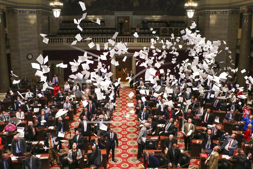 Members of the Missouri House of Representatives end the final day of the regular legislative session with a toss up of papers on Friday, May 15, 2020 at the Missouri State Capitol in Jefferson City, Mo. The House stands adjourned until May 27, when it will hold a tech session lasting until May 30, according to the House's website message board. (Liv Paggiarino/The Jefferson City News-Tribune via AP)