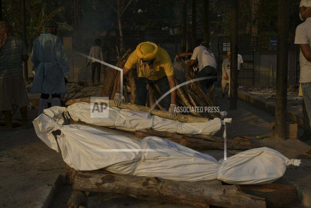 Ishant Chauhan FILE - In this May 10, 2021, file photo, a man places wooden logs on the pyre during the cremation of people who died of COVID-19 at the Seemapuri crematorium in New Delhi, India. The World Health Organization said Monday, May 10, that a worrisome variant was first detected in India may spread more easily. Scientists are still trying to figure out if it resulted in the terrifying surge of infections in the nation, and looking to see if this could this happen elsewhere. (AP Photo/Ishant Chauhan, File)