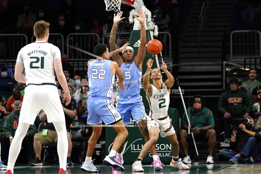 Lynne Sladky Miami guard Isaiah Wong (2) goes for control of the ball as North Carolina forward Justin McKoy (22) and forward Armando Bacot (5) defend during the first half of an NCAA college basketball game, Tuesday, Jan. 18, 2022, in Coral Gables, Fla. (AP Photo/Lynne Sladky)