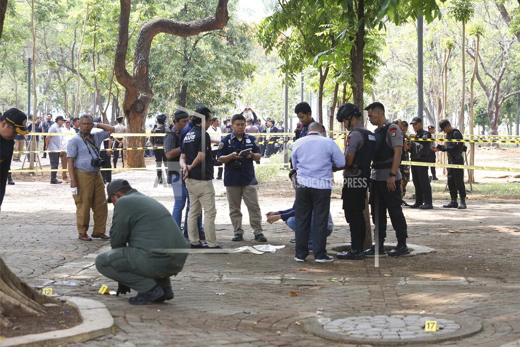 Police investigators inspect the site of an explosion in Jakarta, Indonesia, Tuesday, Dec. 3, 2019. An explosion from a smoke grenade occurred Tuesday near the presidential palace in Indonesia's capital. (AP Photo)