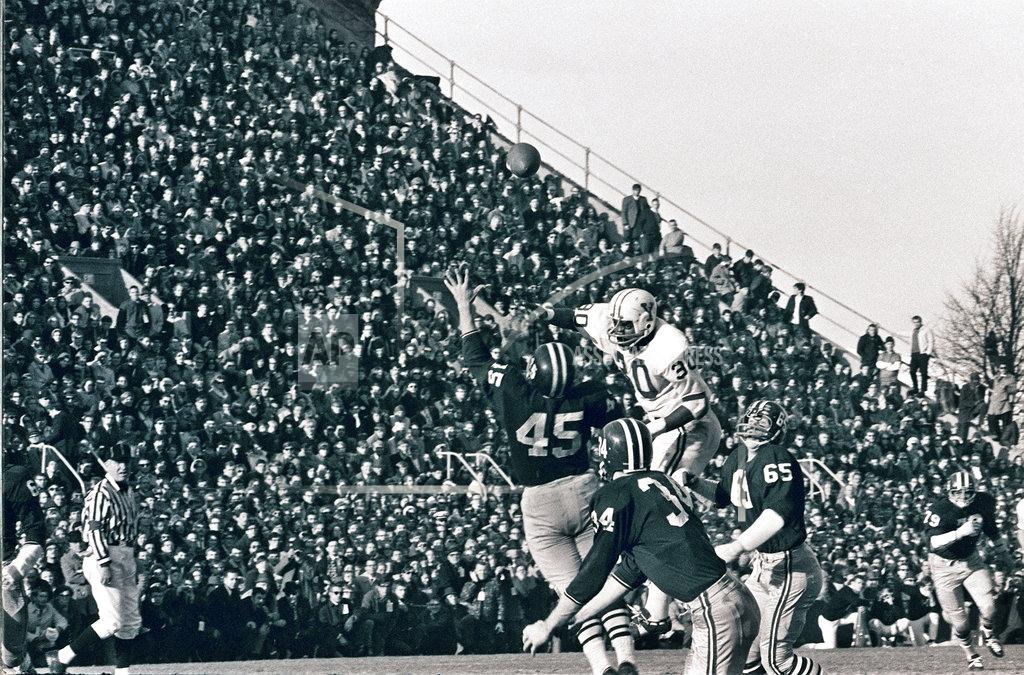 Anonymous FILE - In this Nov. 23, 1968 file photo, Harvard's Tom Wynne (45), Yale's Cal Hill (3) and Harvard's Pat Conway (34) battle for a Yale pass during a college football game at Harvard Stadium in Cambridge, Mass. Sixty-five members of Harvard's 1968 football team are expected back on campus this weekend for the 50th anniversary of The Game's most memorable edition. (AP Photo/File)