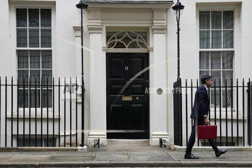 Britain's Chancellor of the Exchequer Rishi Sunak holds the traditional ministerial red dispatch box as he leaves for the House of Commons to deliver the Budget in London, Wednesday, Oct. 27, 2021. (AP Photo/Alastair Grant)