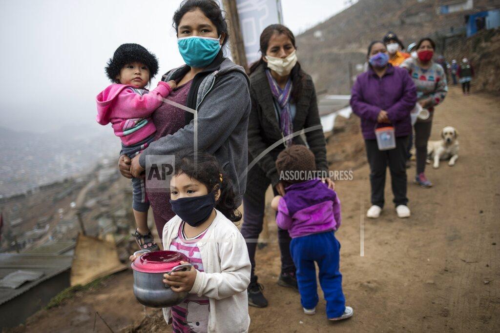 Rodrigo Abd FILE - In this June 17, 2020, file photo, people wearing masks to curb the spread of the new coronavirus wait in a line for a free meal at the Villa Maria del Triunfo district in Lima, Peru. The International Monetary Fund has sharply lowered its forecast for global growth this year because it envisions far more severe economic damage from the coronavirus than it did just two months ago. (AP Photo/Rodrigo Abd, FIle)