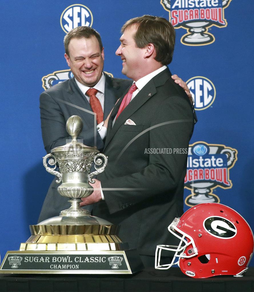 Curtis Compton Georgia head coach Kirby Smart, right, and Texas head coach Tom Herman laugh during their photo opportunity with the Sugar Bowl trophy at a press conference on Monday, Dec 31, 2018, in New Orleans. No. 14 Texas will try to cap an impressive season when it faces No. 6 Georgia in the Sugar Bowl on Tuesday night, Jan. 1, 2019. (Curtis Compton/Atlanta Journal-Constitution via AP)