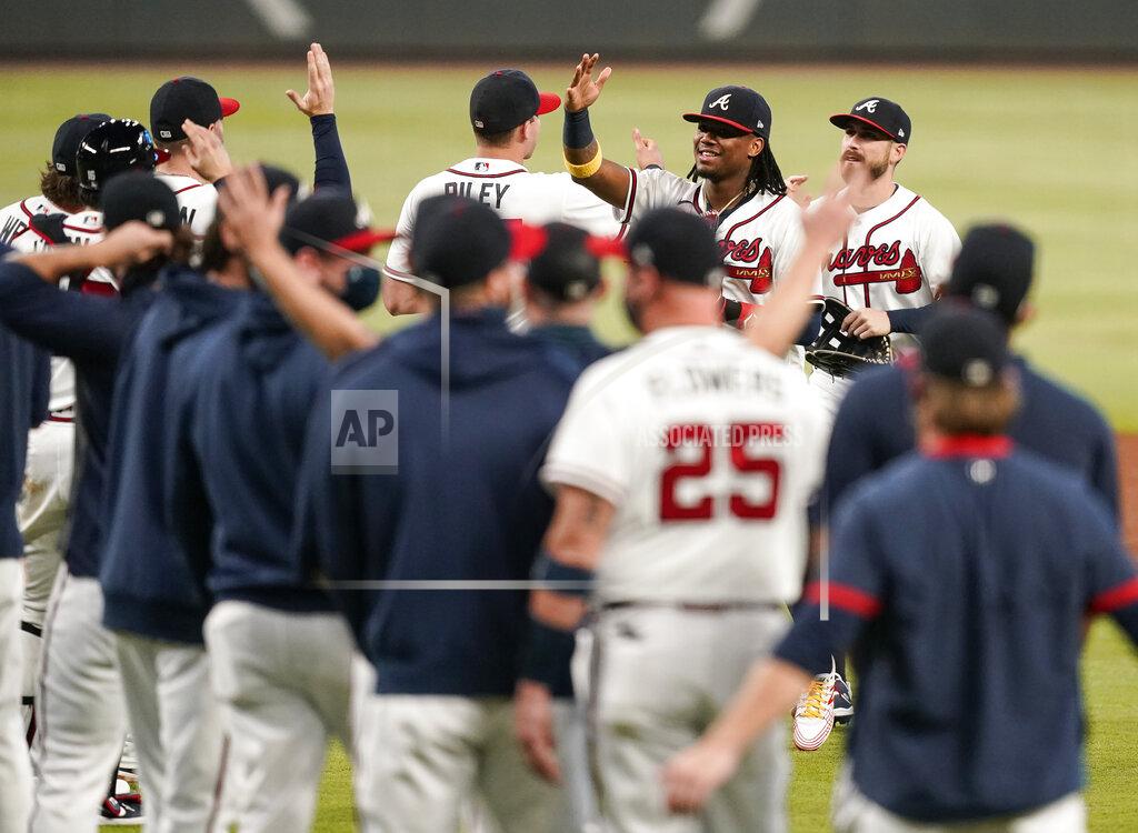 Brynn Anderson Atlanta Braves' Ronald Acuna Jr., right, and the team celebrates after a baseball game to clinch the NL East title against the Miami Marlins on Tuesday, Sept. 22, 2020, in Atlanta. (AP Photo/Brynn Anderson)