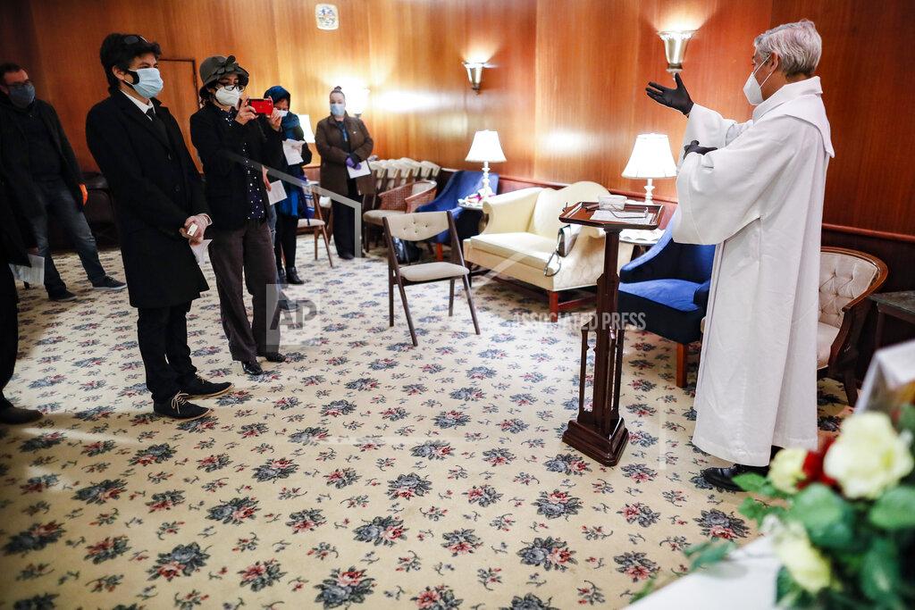 John Minchillo Fabian Arias, a Lutheran pastor with Saint Peter's Church in Manhattan, right, gives a funeral home service besides the casket of Hector Cabana who died of COVID-19, Monday, May 11, 2020, in the Brooklyn borough of New York. (AP Photo/John Minchillo)