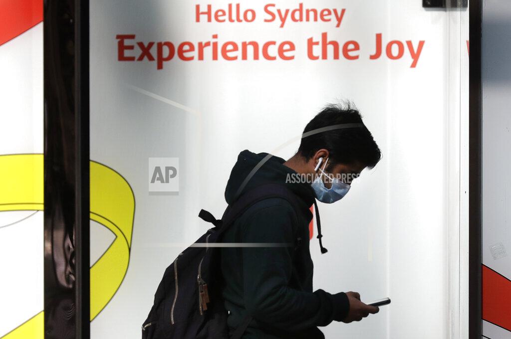 Rick Rycroft A man wears a mask as he walks in Sydney, Wednesday, July 7, 2021. Sydney's two-week lockdown has been extended for another week due to the vulnerability of an Australia population largely unvaccinated against COVID-19, officials said. (AP Photo/Rick Rycroft)