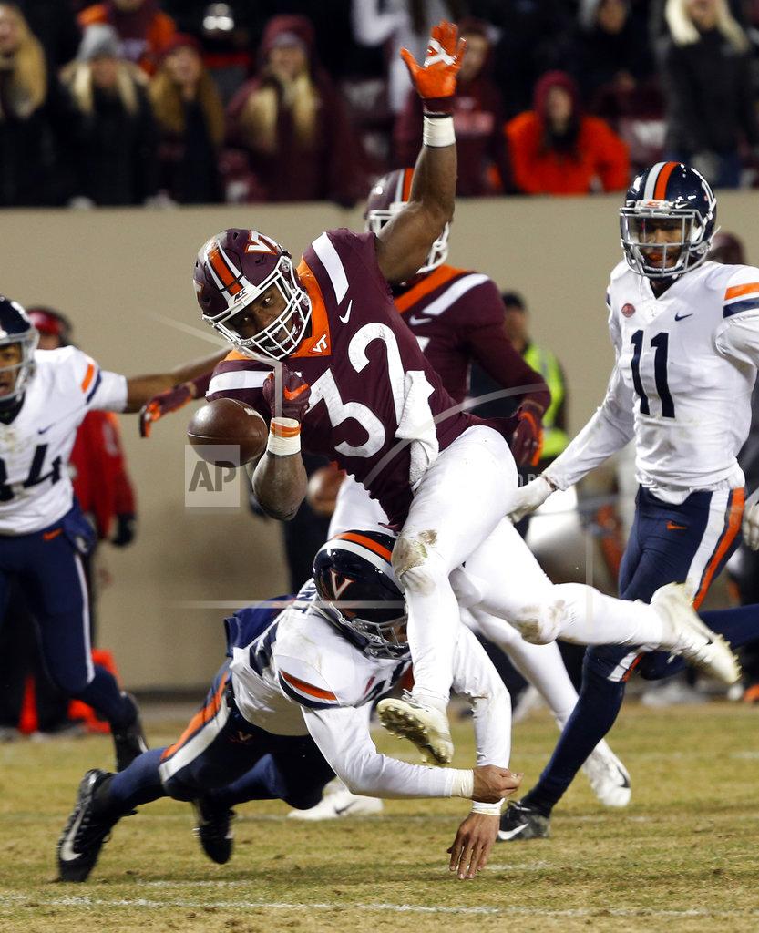 Steve Helber Virginia running back Lamont Atkins (25) tackles Virginia Tech running back Steven Peoples (32) near the end zone as he loses the ball during the second half of an NCAA college football game in Blacksburg, Va., Friday, Nov. 23, 2018. Virginia Tech defeated Virginia 34-31. (AP Photo/Steve Helber)