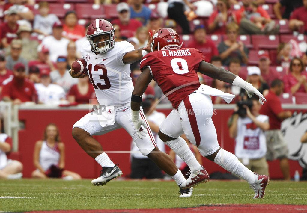 Michael Woods Alabama quarterback Tua Tagovailoa (13) tries to get away from Arkansas defender De'Jon Harris in the first half of an NCAA college football game Saturday, Oct. 6, 2018, in Fayetteville, Ark. (AP Photo/Michael Woods)