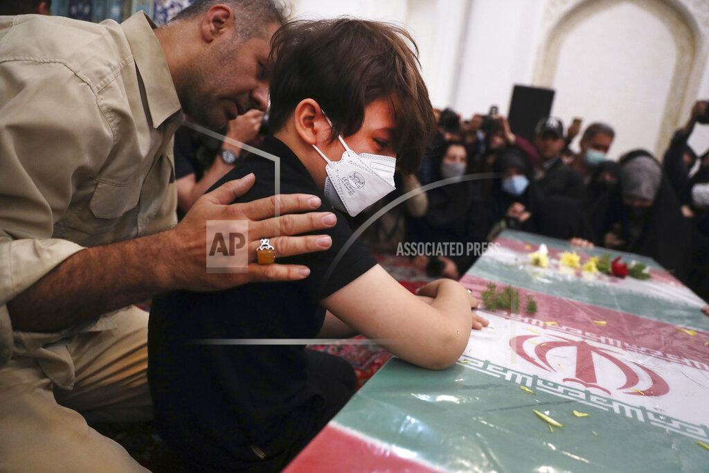 Vahid Salemi Son of Iran's Revolutionary Guard Col. Hassan Sayyad Khodaei who was killed on Sunday weeps over his flag draped coffin during his funeral in Tehran, Iran, Tuesday, May 24, 2022. Iran's hard-line President Ebrahim Raisi vowed revenge on Monday over the killing of Sayyad Khodaei who was shot at his car by two assailants outside his home in Tehran, a still-mysterious attack on the country's powerful paramilitary force. (AP Photo/Vahid Salemi)