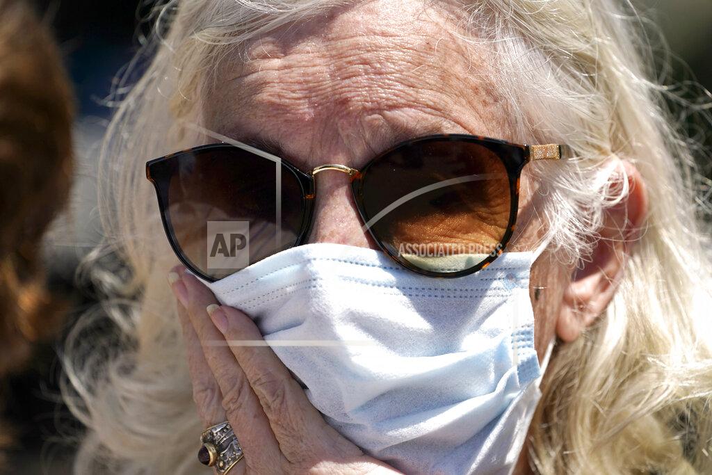 David J. Phillip CORRECTS SPELLING OF FIRST NAME TO ELISABETH INSTEAD OF ELIZABETH - Elisabeth Pelham waits to board a bus to evacuate, Tuesday, Aug. 25, 2020, in Galveston, Texas. The evacuees are being taken to Austin, Texas, as Hurricane Laura heads toward the Gulf Coast. (AP Photo/David J. Phillip)