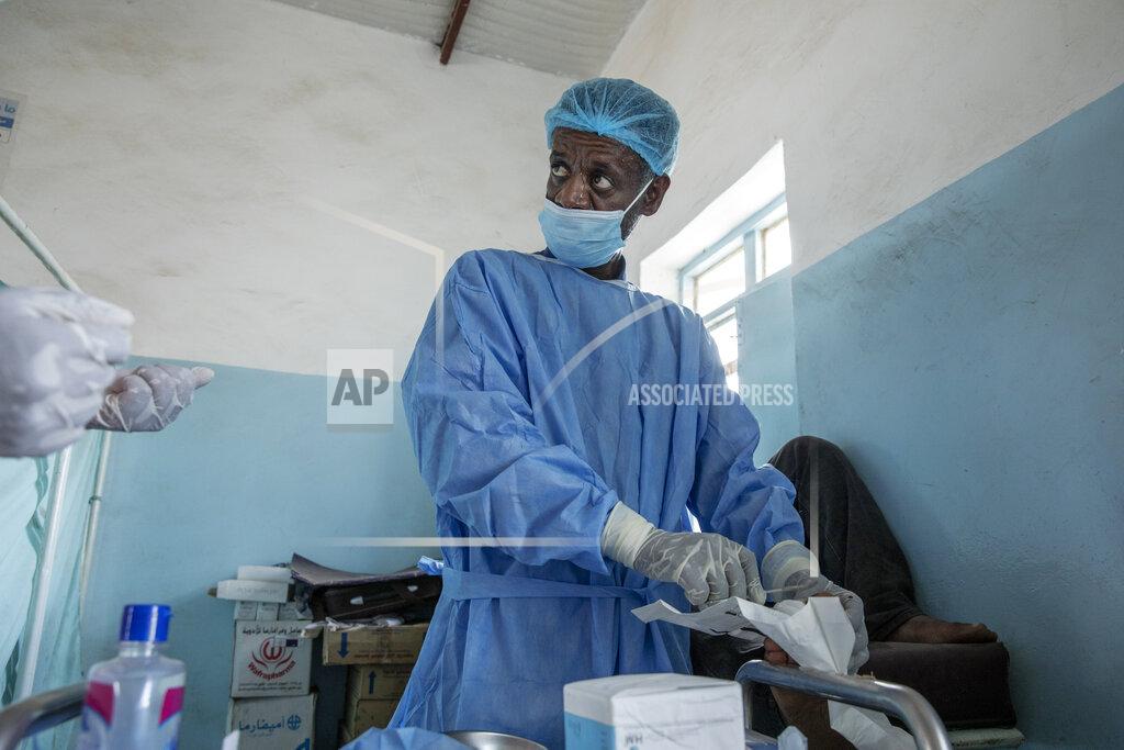 Nariman El-Mofty Surgeon and doctor-turned-refugee, Dr. Tewodros Tefera, performs surgery on a man's severely infected toe, inside the Sudanese Red Crescent clinic, in Hamdayet, eastern Sudan, near the border with Ethiopia, on March 22, 2021. (AP Photo/Nariman El-Mofty)