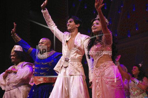 This image released by Disney Theatrical Productions shows, from second left, Michael James Scott as Genie, Michael Maliakel as Aladdin, and Shoba Narayan as Jasmine after a performance of the Broadway musical "Aladdin" in New York on Sept. 28, 2021. (Curtis Brown/Disney Theatrical Productions via AP)