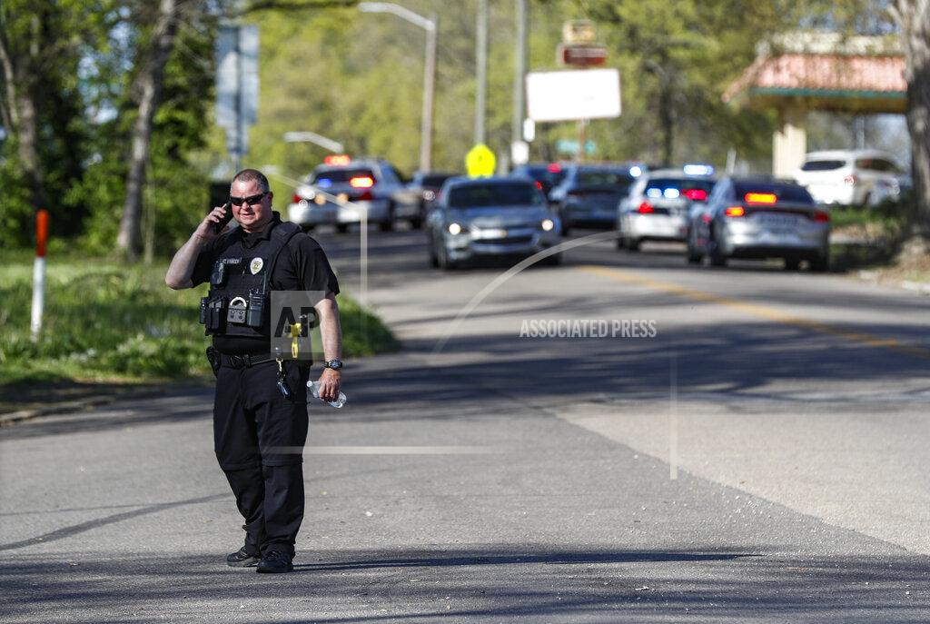 Wade Payne A Knoxville police officer talks on the phone at the scene of a shooting at Austin-East Magnet High School Monday, April 12, 2021, in Knoxville, Tenn. (AP Photo/Wade Payne)