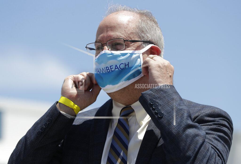 Wilfredo Lee Miami Beach Mayor Dan Gelber adjusts his masks before speaking during a news conference along with other South Florida Mayors, Monday, June 22, 2020, in Miami. More than 100,000 people in Florida have been diagnosed with the coronavirus, state health officials reported Monday, as public health officials reissued advisories urging social distancing and mask wearing. (AP Photo/Wilfredo Lee)