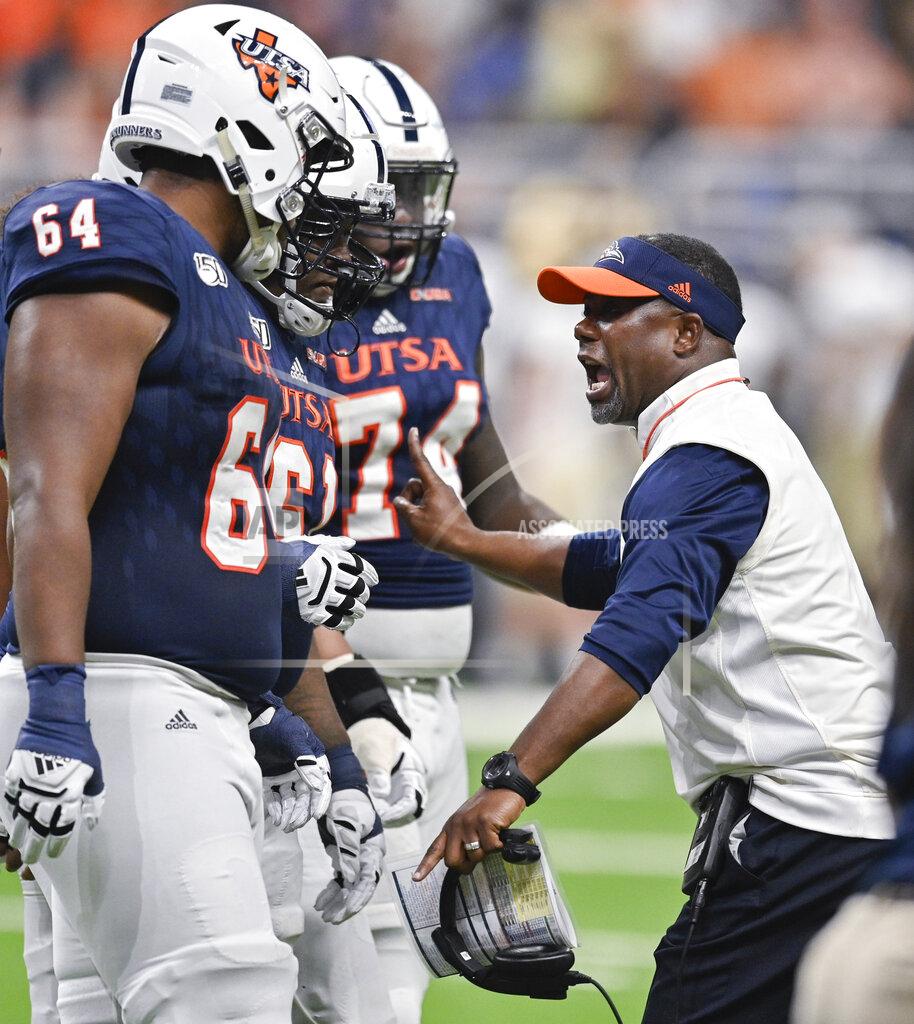 Darren Abate UTSA head coach Frank Wilson, right, talks to players, from left to right, Josh Dunlop Kevin Davis and Spencer Burford during the first half of an NCAA college football game against Army, Saturday, Sept. 14, 2019 in San Antonio. (AP Photo/Darren Abate)