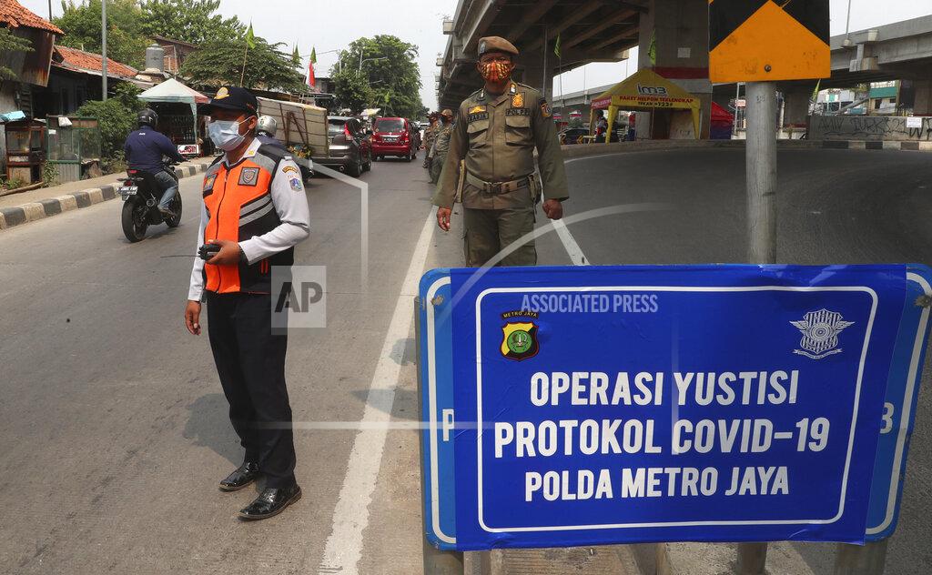Achmad Ibrahim Officers stand guard at a police check point as the large-scale restriction is imposed to curb the spread of the coronavirus outbreak in Jakarta, Indonesia, Monday, Sept. 14, 2020. Indonesia's capital on Monday begins to reimpose large-scale social restrictions to control a rapid expansion in the virus cases. (AP Photo/Achmad Ibrahim)