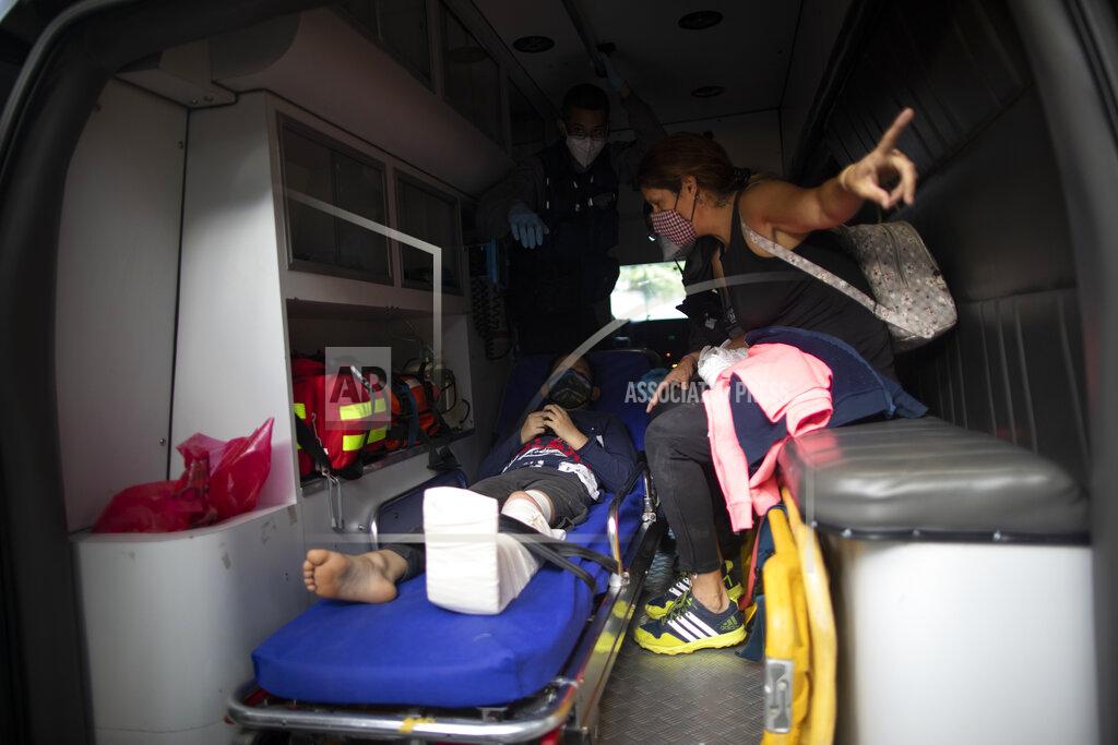 A boy who was involved in a motorcycle accident is transported to the hospital by Angels of the Road volunteer paramedics in their only ambulance in Caracas, Venezuela, Thursday, Feb. 4, 2021. The volunteer corps relies on donated medical supplies and funding from international organizations to provide much-needed emergency services, operating entirely independent of the government. (AP Photo/Ariana Cubillos)