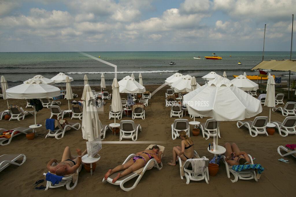 Emrah Gurel Tourists sunbathing at the beach of Antalya , southern Turkey, on Sunday, June 20, 2021. Hotels in Turkey's Antalya region, a destination beloved by holidaymakers, are preparing to finally resume operations as they expect the return of international tourists after months of setbacks caused by the pandemic that halted travel. (AP Photo/Emrah Gurel)