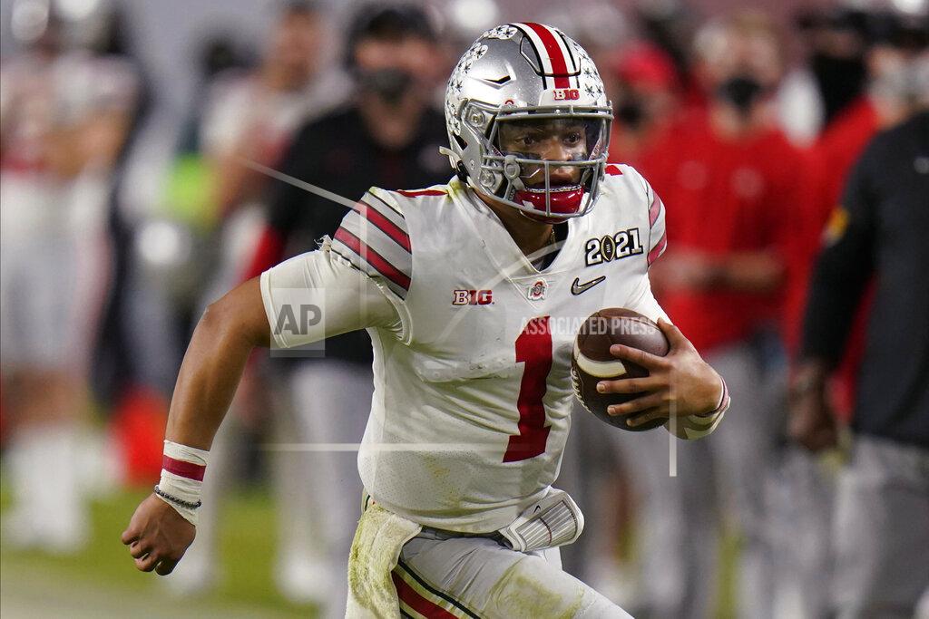 Chris O'meara FILE - In this Monday, Jan. 11, 2021 file photo, Ohio State quarterback Justin Fields runs against Alabama during the second half of an NCAA College Football Playoff national championship game in Miami Gardens, Fla. The last NFL event not impacted by the COVID-19 pandemic was the 2020 combine in Indianapolis. A year later, with the 2021 combine canceled, the league has released a list of players who would have merited invitations. From such high-profile quarterbacks as Clemson’s Trevor Lawrence and Ohio State’s Justin Fields to guys who sat out last season such as Oregon tackle Penei Sewell, there are 323 players from 100 schools. (AP Photo/Chris O'Meara, File)