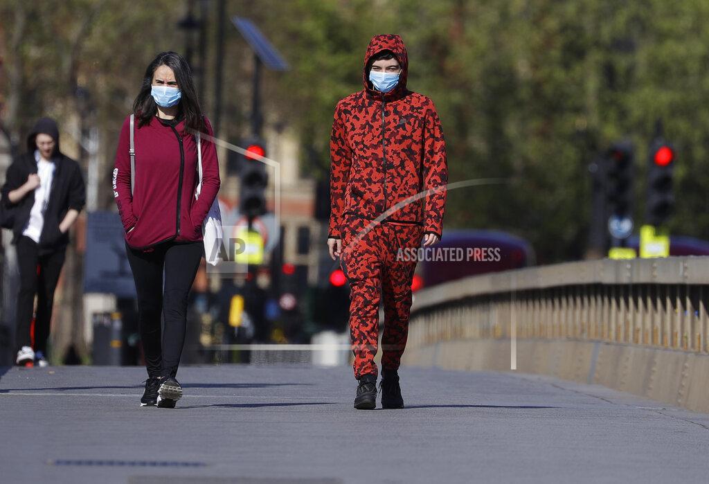 Kirsty Wigglesworth People wear protective face masks as they walk in Westminster in London, as the country is in lockdown to help curb the spread of coronavirus, Tuesday, April 21, 2020. (AP Photo/Kirsty Wigglesworth)