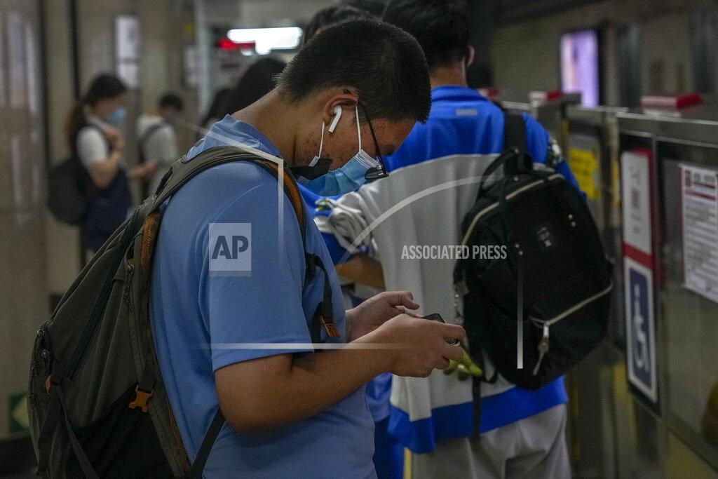 Andy Wong A student plays an online game on his smartphone as he waits for his train at a subway station in Beijing Tuesday, Sept. 14, 2021. China has set new rules limiting the amount of time kids can spend playing online games. (AP Photo/Andy Wong)