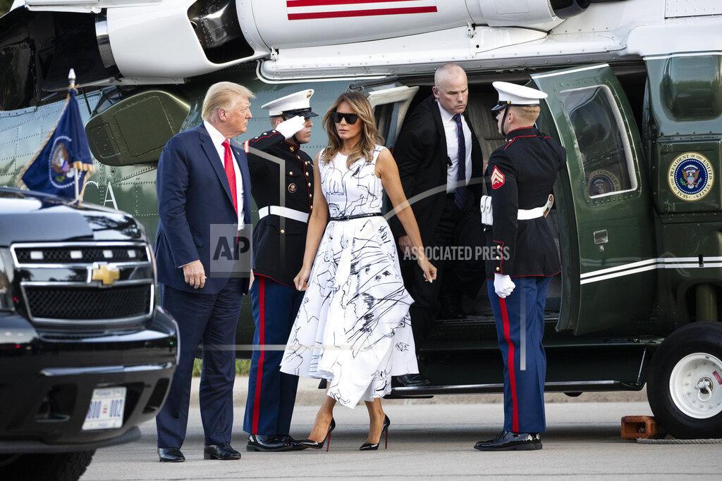 Alex Brandon FILE - In this Friday, July 3, 2020 file photo, President Donald Trump, accompanied by first lady Melania Trump, step off Marine One as they arrive at Mount Rushmore National Memorial near Keystone, S.D. On Friday, July 10, 2020, The Associated Press reported on stories circulating online incorrectly asserting the dress Melania Trump wore during Fourth of July celebrations featured drawings by various victims of child sex trafficking. The sketches on the dress were made by design students from the British art school Central Saint Martins. (AP Photo/Alex Brandon)