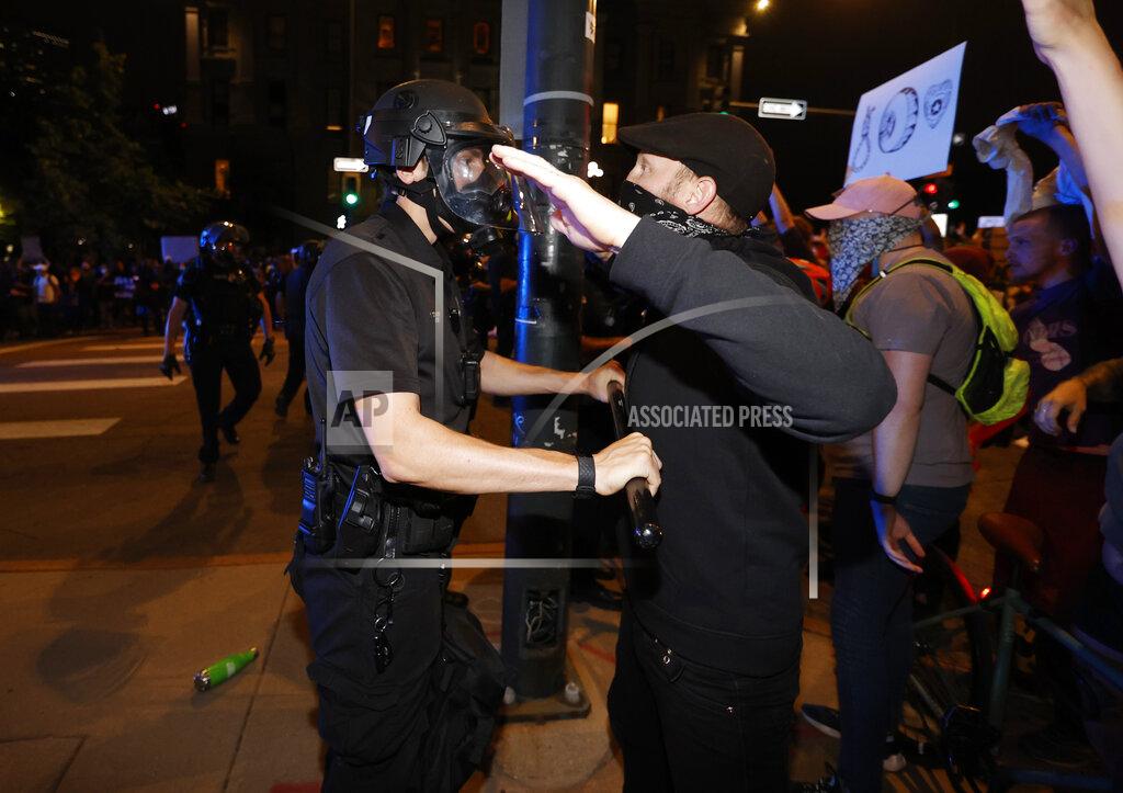 David Zalubowski A Denver police officer uses a baton to push back protester outside the State Capitol on Thursday, May 28, 2020, in Denver, during a demonstration over the Monday death of George Floyd in Minneapolis police custody. (AP Photo/David Zalubowski)