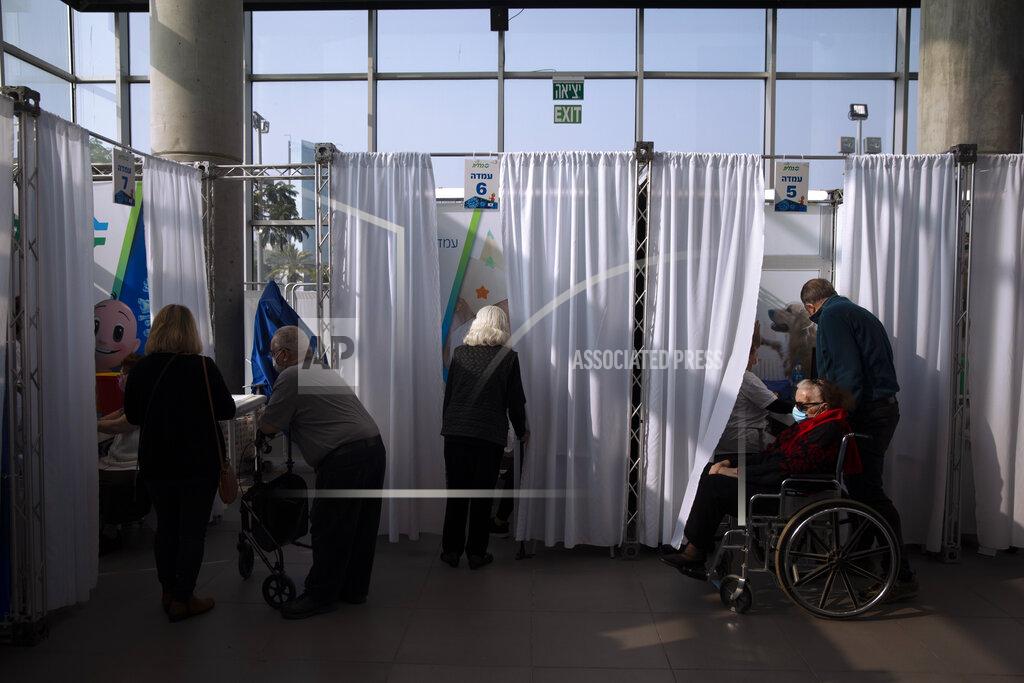 Oded Balilty People wait to receives a coronavirus vaccine from medical staff at a COVID-19 vaccination center in Tel Aviv, Israel, Tuesday, Jan. 5, 2021. With elections approaching in March, Israeli Prime Minister Benjamin Netanyahu has placed his world-leading vaccination drive at the center of his re-election campaign launching an aggressive media blitz portraying him as almost singlehandedly leading the country out of the pandemic. (AP Photo/Oded Balilty)