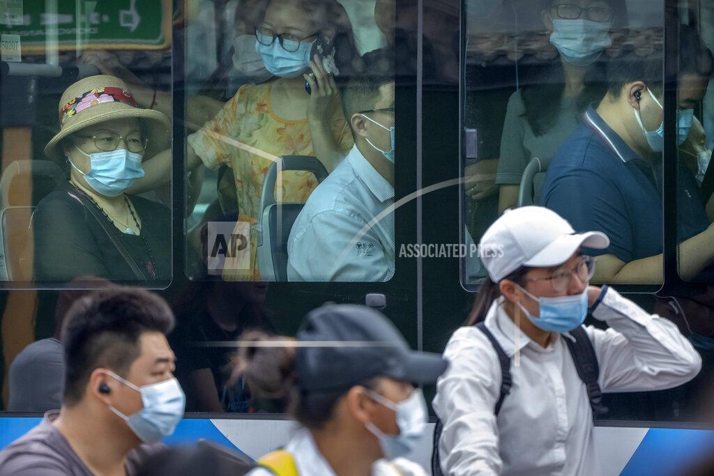 Mark Schiefelbein People wearing face masks to protect against COVID-19 ride on a bus during the morning rush hour in Beijing, Wednesday, Aug. 4, 2021. The coronavirus's delta variant is challenging China's costly strategy of imposing near-total isolation on any budding hotspots, prompting warnings from health experts that Chinese leaders who were confident they could keep the virus at bay need a less disruptive approach. (AP Photo/Mark Schiefelbein)