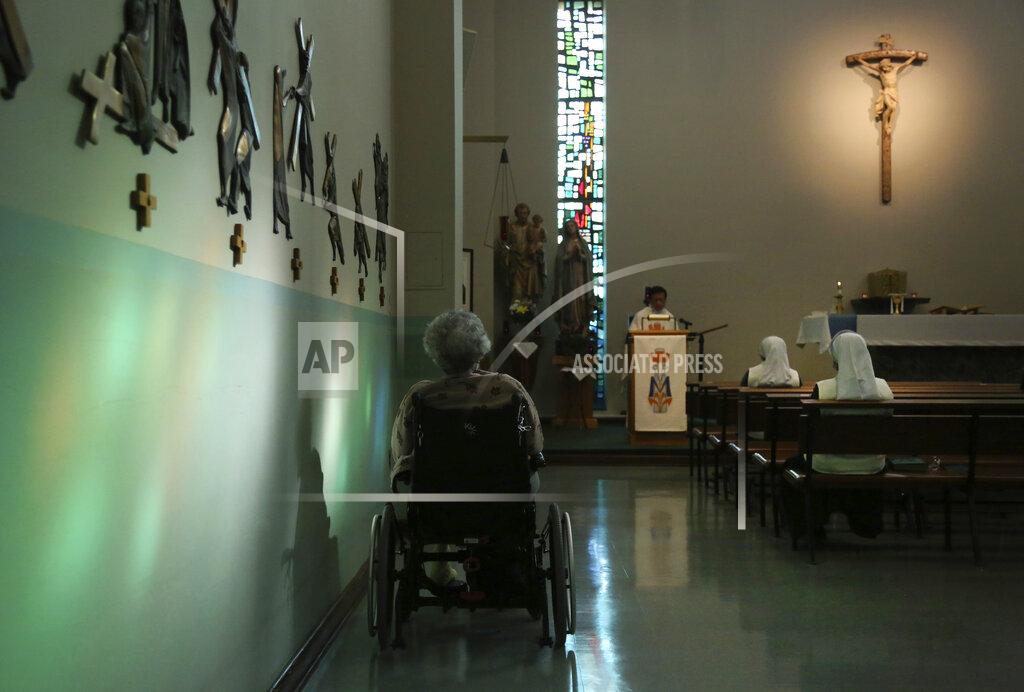 Jessie Wardarski A resident of St. Anne Home sits bathed in sunlight streaming through a stained glass window during morning Mass attended by nuns and residents of the nursing facility in Greensburg, Pa., on Thursday, March 25, 2021. (AP Photo/Jessie Wardarski)