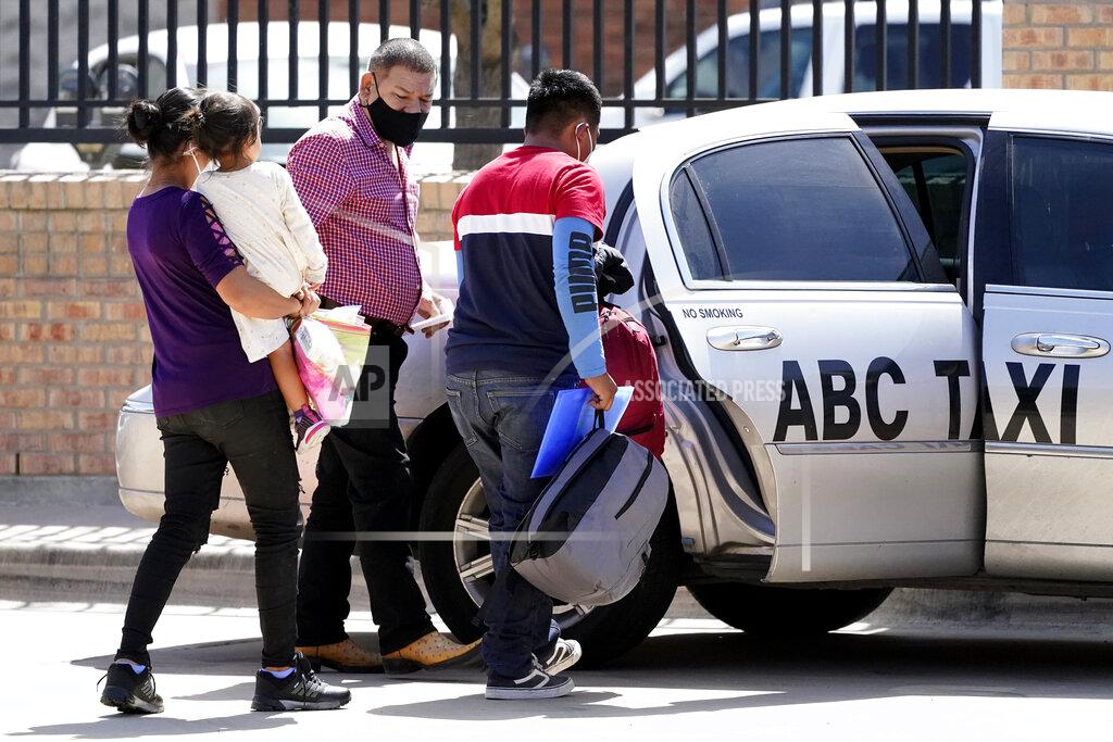 Julio Cortez Larissa Bautista Hernandez, 2, second from left, a migrant from Honduras, is carried by her mother, Irma Hernandez, left, as her father, Jose Frankis Bautista, right, heads into a taxi cab at a bus station, Wednesday, March 17, 2021, in Brownsville, Texas. The family is seeking asylum from the U.S. and is getting help from Team Brownsville, a humanitarian group, to reach their final destination with Bautista's brother in South Carolina. A surge of migrants on the Southwest border has the Biden administration on the defensive. The head of Homeland Security acknowledged the severity of the problem Tuesday but insisted it's under control and said he won't revive a Trump-era practice of immediately expelling teens and children. (AP Photo/Julio Cortez)