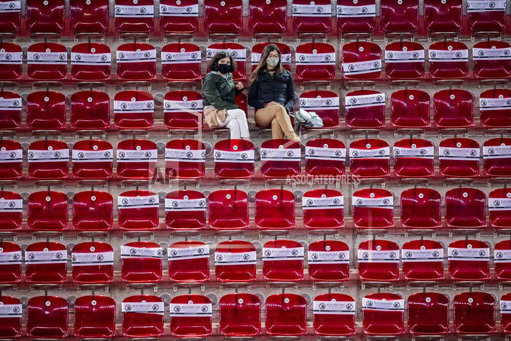 Spectators follow the match between United States' Shelby Rogers and Ashleigh Barty during the Mutua Madrid Open tennis tournament in Madrid, Spain, Thursday, April 29, 2021. The white banners covering the seats read "Do not sit here. Keep social distance". (AP Photo/Bernat Armangue)