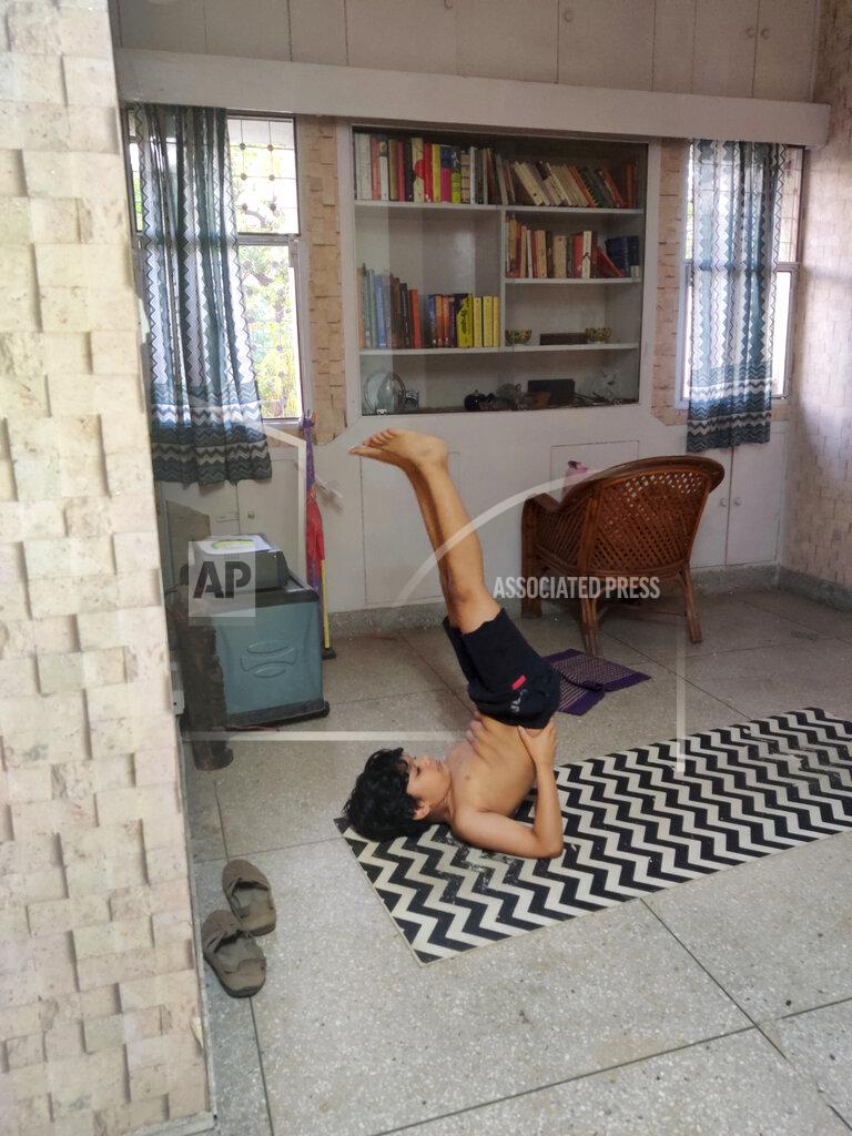 Anil Sanweris In this Tuesday, April 21, 2020 photo provided by Anil Sanweria, his son, Uddhav Pratap, 8, practices yoga in their home during a nationwide COVID-19 coronavirus lockdown. (Anil Sanweria via AP)