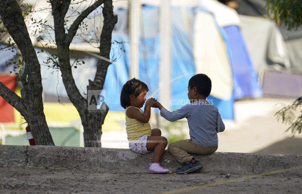 Children play at a camp of asylum seekers stuck at America's doorstep, in Matamoros, Mexico, on Wednesday, Nov. 18, 2020. Like countless schools, the camp's so-called sidewalk school as it became known went to virtual learning amid the coronavirus pandemic but instead of being hampered by the change, it has blossomed. (AP Photo/Eric Gay)