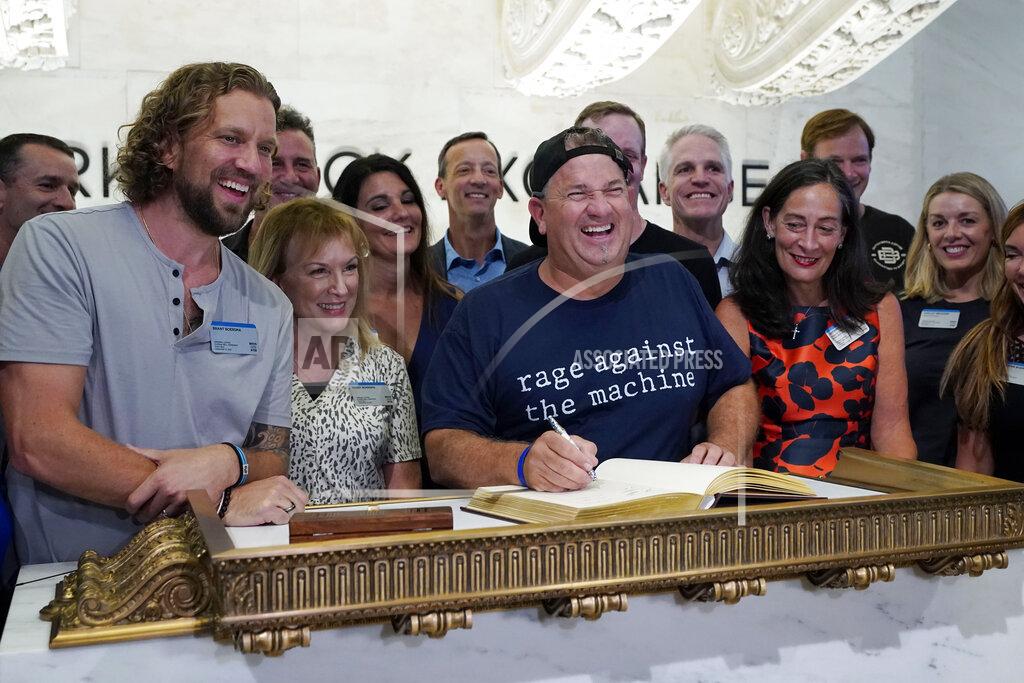Richard Drew Dutch Bros Coffee Co-founder and Executive Chairman Travis Boersma, center, poses for photos as he signs the New York Stock Exchange guest book, before ringing the closing bell, Wednesday, Sept. 15, 2021. (AP Photo/Richard Drew)