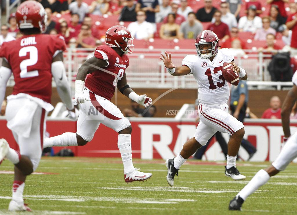 Michael Woods Alabama quarterback Tua Tagovailoa (13) tries to get away from Arkansas defender De'Jon Harris in the first half of an NCAA college football game Saturday, Oct. 6, 2018, in Fayetteville, Ark. (AP Photo/Michael Woods)