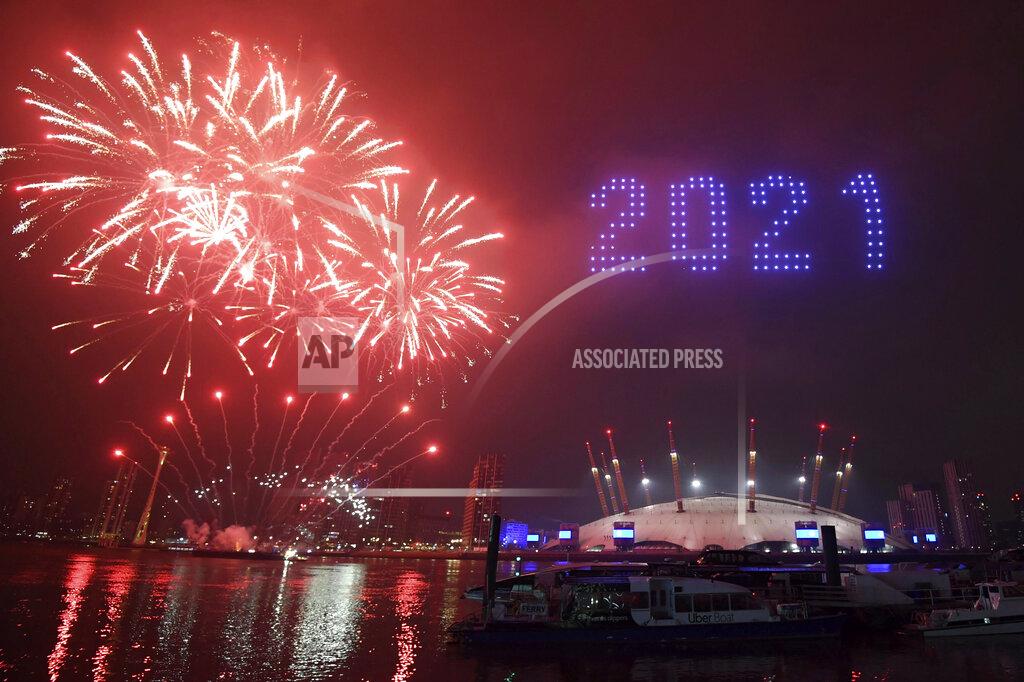 Victoria Jones Fireworks and drones illuminate the night sky over London as they form a light display as London's normal New Year's Eve fireworks display was cancelled due to the coronavirus pandemic Thursday Dec. 31, 2020. (Victoria Jones/PA via AP)