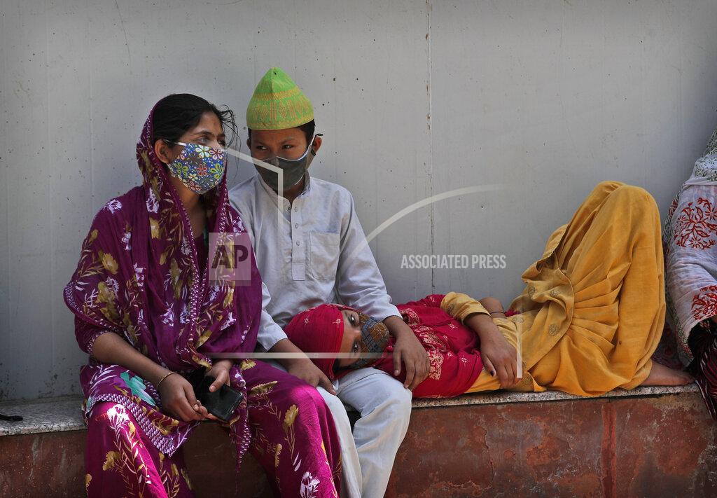 Manish Swarup A family waits to receive the body of a person who died due to COVID-19 outside a mortuary, in New Delhi, India, Monday, April 19, 2021. India's health system is collapsing under the worst surge in coronavirus infections that it has seen so far. (AP Photo/Manish Swarup)