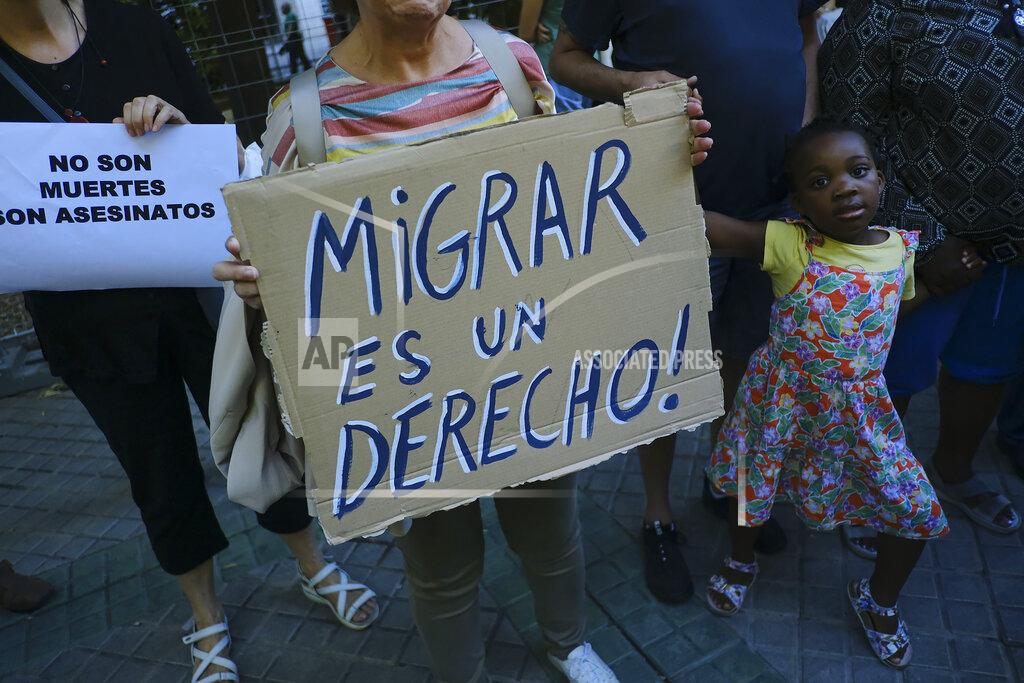 Alvaro Barrientos A woman holds up a banner that reads: "Migration is a right", during one of many protests across Spain amid for the investigation over the deaths of at least 23 people at the border between the Spanish enclave of Melilla and Morocco, in Pamplona, northern Spain, Friday, July 1, 2022. (AP Photo/Alvaro Barrientos)