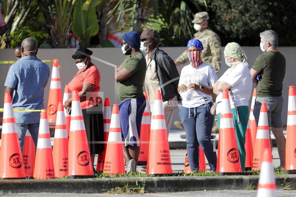 Lynne Sladky People wait in line to be tested for COVID-19 at a walk-up testing site outside of the Holy Family Catholic Church, during the new coronavirus pandemic, Tuesday, April 28, 2020, in North Miami, Fla. (AP Photo/Lynne Sladky)