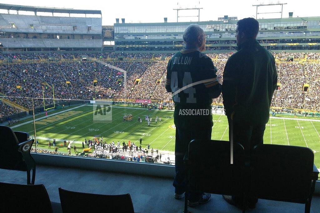 Uncredited In this October 2012 photo provided by Karen Gooch, former Green Bay Packers football player Bobby Dillon and his grandson, Weston Gooch are shown in a suite at Lambeau Field in Green Bay, Wisc. He left with an outstanding resume, but also with the ugly remnants of a series of concussions from playing football. Of the 26 men who entered the Pro Football Hall of Fame as Packers and preceded Bobby Dillon into the shrine, nearly all won an NFL championship in Green Bay. Dillon never got the chance. (Karen Gooch via AP)
