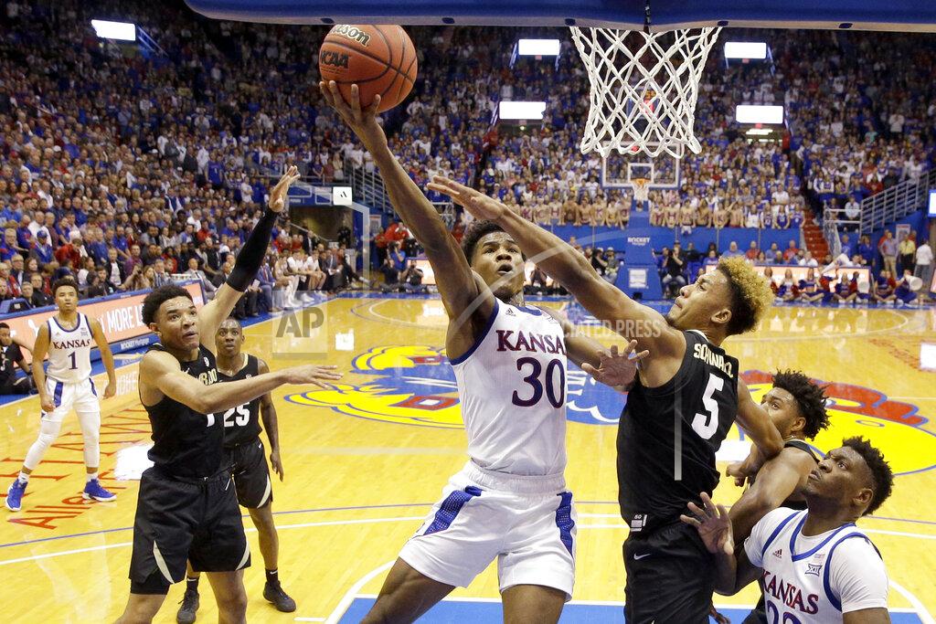 Charlie Riedel Kansas' Ochai Agbaji (30) gets past D'Shawn Schwartz (5) to shoot during the first half of an NCAA college basketball game Saturday, Dec. 7, 2019, in Lawrence, Kan. Kansas won 72-58. (AP Photo/Charlie Riedel)