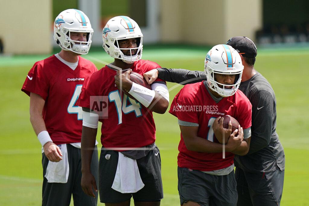 Wilfredo Lee Miami Dolphins quarterbacks Tua Tagovailoa, right, Jacoby Brissett, center, and Reid Sinnett, left, run drills during a mandatory minicamp at the NFL football team's training camp, Tuesday, June 15, 2021, in Davie, Fla. (AP Photo/Wilfredo Lee)